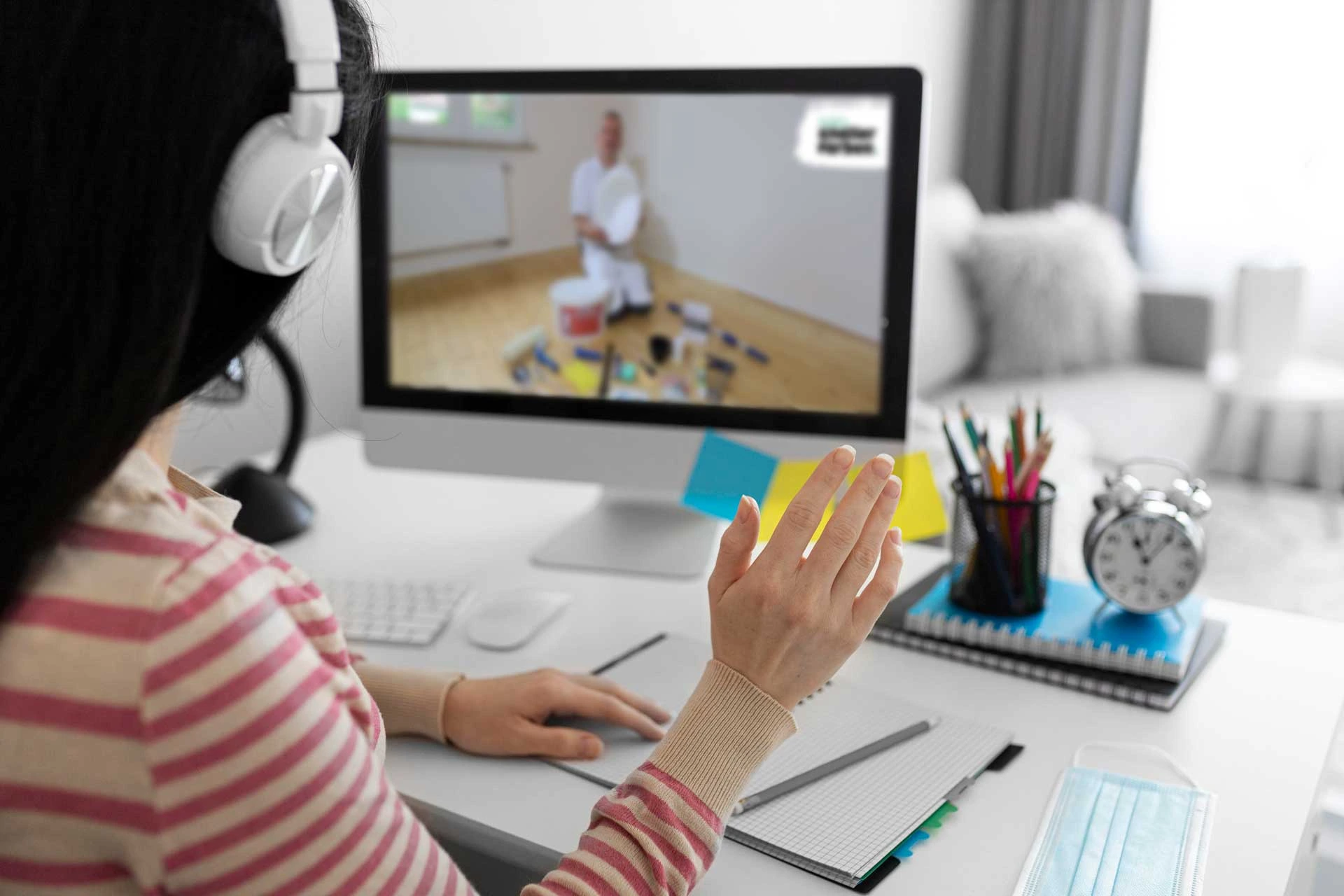 Eine Frau sitzt vor dem Computer. Auf dem Bildschirm ist Jokel zu sehen, mit dem sie per Videocall spricht.